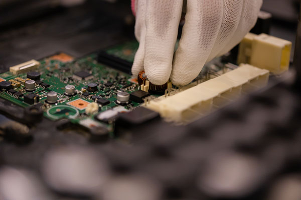 Tecnico reparando una placa madre electronica